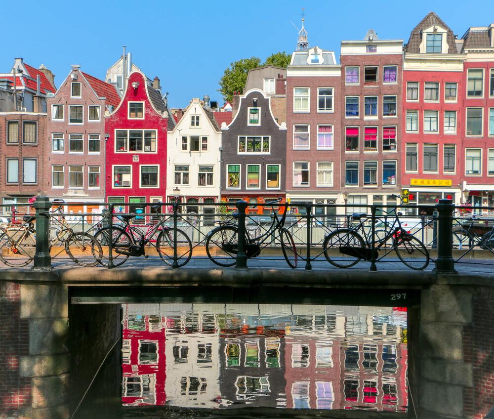 bikes in front of colorful buildngs amsterdam neighborhoods
