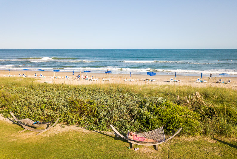 aerial of woman on hammock on grassy area in front of Wrightsville Beach NC