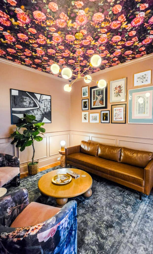 seating area with wallpaper ceiling in hidden house charleston
