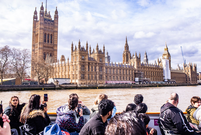 people taking photos of parliament house from boat