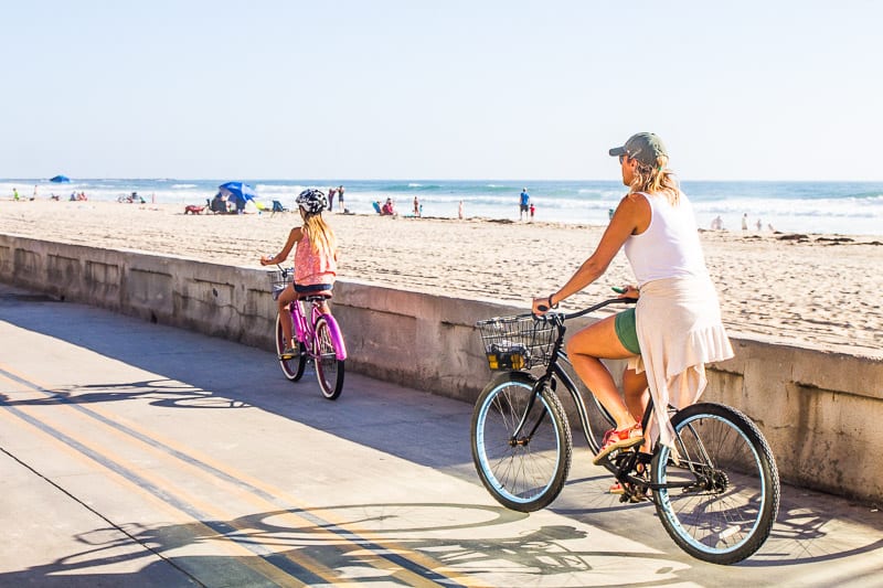 woman and girl Bike riding along Pacific Beach, San Diego