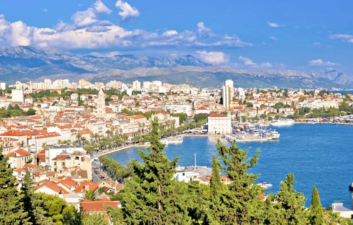 aerial view of split town and harbor with mountains in background