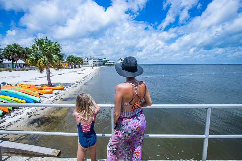 woman and child standing on pier looking at cedar key beach