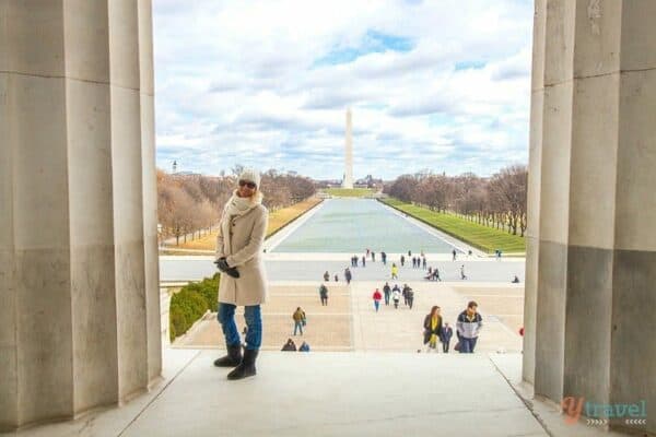woman standing in side Abraham Lincoln Memorial with view of national mall behind